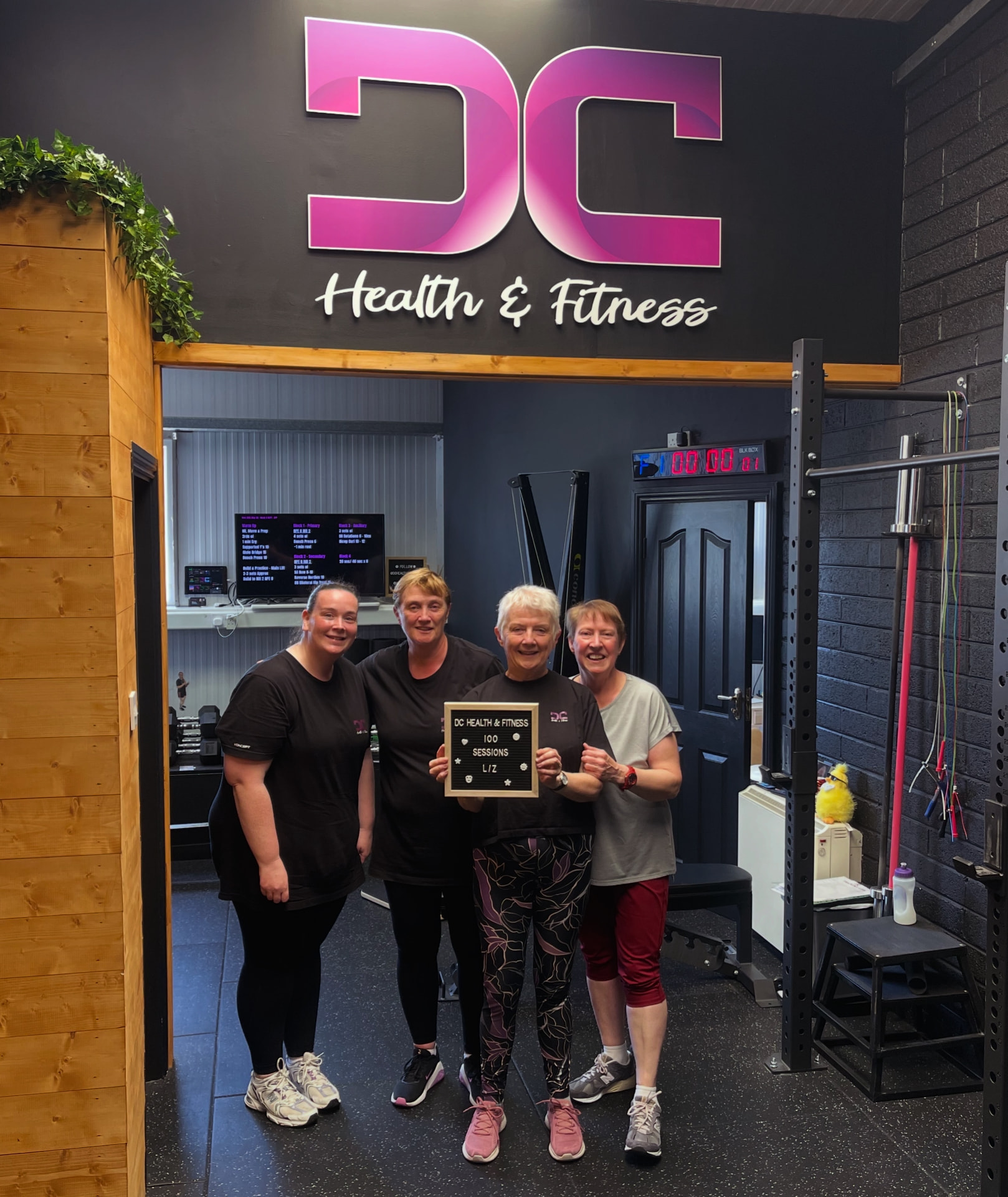 Small group personal training members celebrating 100 sessions at DC Health & Fitness